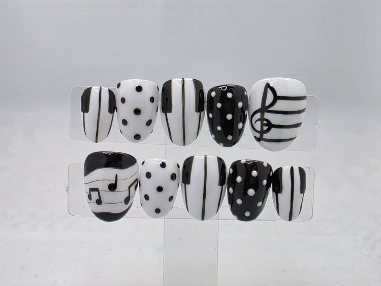 Piano Perfect black-and-white press-on nail set with piano keys, musical notes, a treble clef, and polka dots